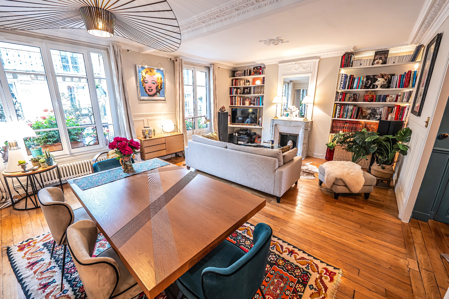 Salon lumineux haussmannien avec bibliothèque